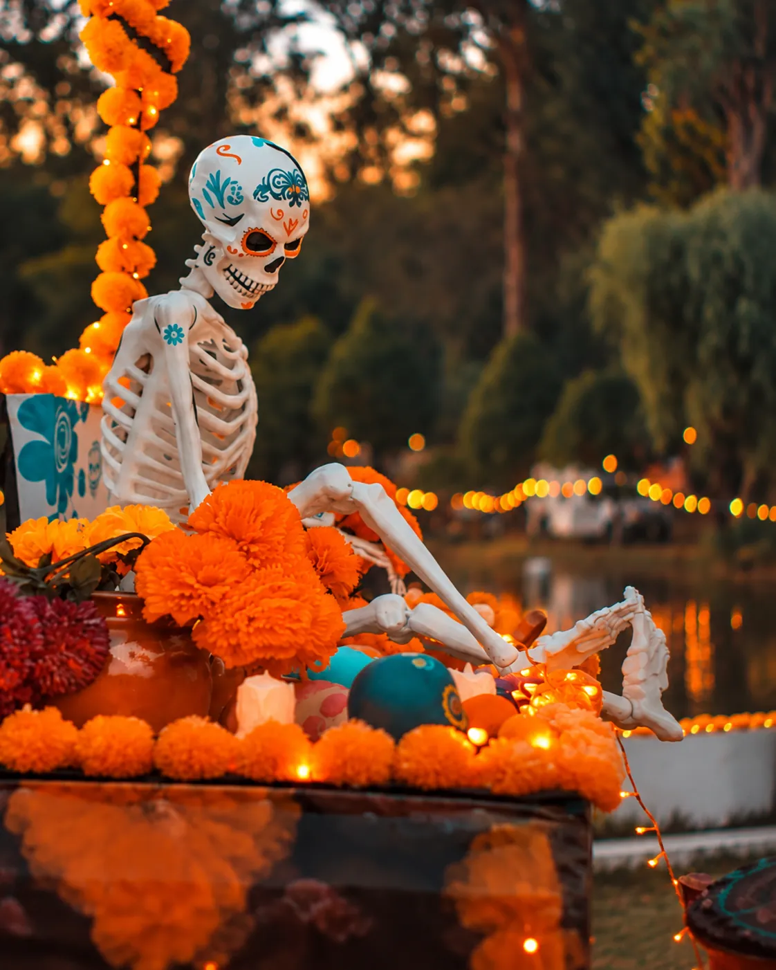 Figura de calavera entre flores de cempasúchil al anochecer